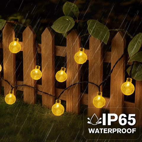 Solar String Lights For Outdoor 20Ft 30 LED Crystal Globe Fairy Lights Warm White With 8 Lighting Modes on wooden fence in rain