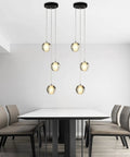 Raindrop Crystal Cluster Pendant Light With Bubble Orb Design 3 Light Hanging Fixture over dining table in modern room.