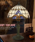 Vintage Tiffany Style Glass Table Lamp With Eye Catching Shade on wooden desk, soft glow enhancing cozy decor