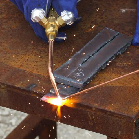 Welding handle with a hose connection and front valves brass ribbed forged handle built tough, in use on metal welding surface