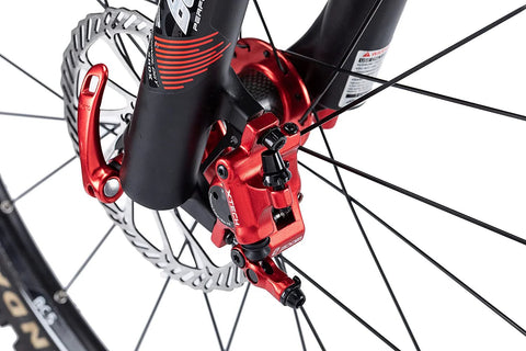Red XTECH aluminum alloy hydraulic disc brake caliper, front view on MTB fork with rotor visible