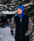 Man in blue hat wearing Heavy Duty Kick Ass 100 Percent Merino Wool Men Vest Expedition Grade Heavyweight in snow.