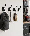 Solid Build Vintage Black Wall Hooks Heavy Duty Coat And Towel Rack Four Pack holding a backpack, hammer, and gloves on a wall.