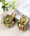 4 Pack 2.5 Inch Sliding Gate Wheels With 360 Degree Rotational Stem And V Groove Caster, displayed on a table with decorative items.