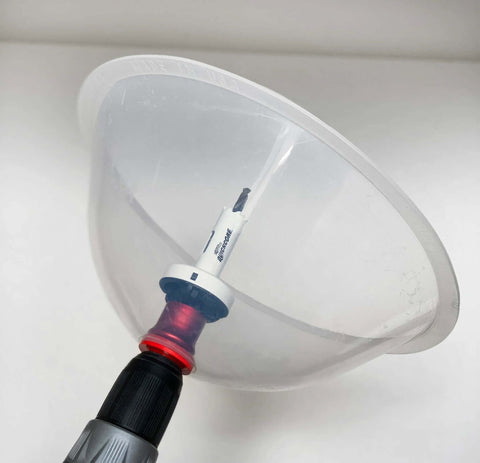 Front view of clear plastic dust bowl attachment for hole saws with drill-bit adapter and red collar
