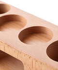 Top view of premium wooden espresso tamping station designed for 58mm portafilters featuring slots for dosing needles.