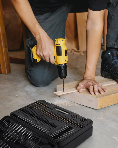 Person using a drill from the 400 Piece Drill Bit Set With Drawer Case For Metal Wood And Masonry Pro Grade Drill And Screwdriver Bit Kit For Quick Drilling And Driving Perfect For DIY Projects, with open case visible.
