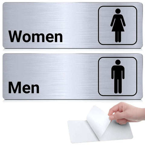 Two Pack Aluminum Restroom Signs For Men And Women Self Adhesive Metal Bathroom Door Wall Signage For Offices Restaurants Public Places 9 By 3 Inches Silvery Finish Easy Mount showing "Women" and "Men" signs.