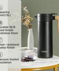 Double Walled Stainless Steel Thermal Coffee Carafe 51 Oz Keeps Your Drinks Hot Or Cold For Hours, 1.5 L Beverage Dispenser With BPA Free Lid, Black on a table with flowers and coffee cups