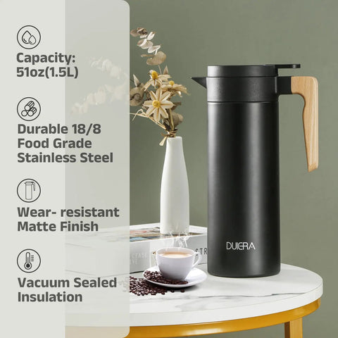 Double Walled Stainless Steel Thermal Coffee Carafe 51 Oz Keeps Your Drinks Hot Or Cold For Hours, 1.5 L Beverage Dispenser With BPA Free Lid, Black on a table with flowers and coffee cups