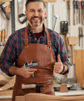 Man in leather apron holding Heavy Duty Mini Work Bench Vise With Adjustable Quick Release Clamp for DIY projects.