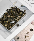 Top Shelf Brass Upholstery Tacks For Furniture Restoration, 200 Piece Box of decorative nail pins in a clear container.