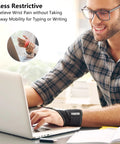 Man typing on laptop wearing Air Mesh Wrist Brace For Carpal Tunnel Pain Relief With Breathable Compression And All Day Comfort