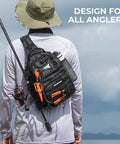Angler wearing BaitSpace Standard Fishing Tackle Sling Bag Water Resistant Pack with rod holder and beverage space, rear view.