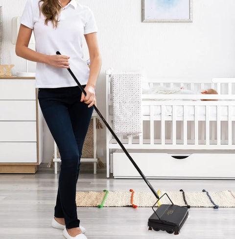 Woman using Electrostatic Carpet And Floor Sweeper Boasts A Nine Inch Cleaning Path For Tile And Rug on hardwood floor.