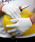 Person holding yellow hard hat and pliers, wearing Cotton Work Gloves 12 Pairs For Painters Mechanics Garden Outdoor Jobs Durable White Knit Gloves