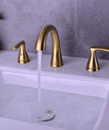Two-Handle 8-Inch Gold Widespread Bathroom Faucet With Pop-Up Drain running water, brushed gold finish, installed on white sink.