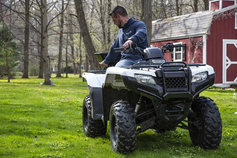 Man on ATV with Beefy ATV Broadcast Spreader With Rain Cover, 100 Pound Capacity Poly Hopper, Rear Rack Mount, on grassy lawn