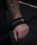 Sick Grip Black Cotton Lifting Wrist Straps Featuring Hella Padded Neoprene Cuffs, close-up of wrist strap on a hand.