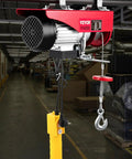 Heavy Duty 2000 Lbs Electric Hoist Crane With 39 Foot Wire Rope Wired Remote Control showing motor and remote in a workshop.