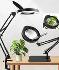 15X Magnifying Glass Lamp With Real Glass Lens And Stand For Reading Crafts Painting And Repair Four Point Three Inch Crystal Clear Magnifier RTM Safety Protection Five Color Stepless Dimmable Eye Caring LED DIY Friendly 2 In 1 Hands Free Desk Clamp, showing clamp and lens setup on a wooden desk.