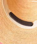 Black reducer strip from 30-Piece Hat Size Reducer Tape Set For Hats And Caps placed inside straw hat, showing application.