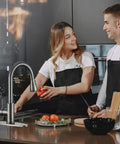 SOEBIZ Grey Kitchen Faucets with Pull Down Sprayer in use by couple cooking in modern kitchen with fresh vegetables.