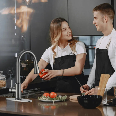 SOEBIZ Grey Kitchen Faucets with Pull Down Sprayer in use by couple cooking in modern kitchen with fresh vegetables.