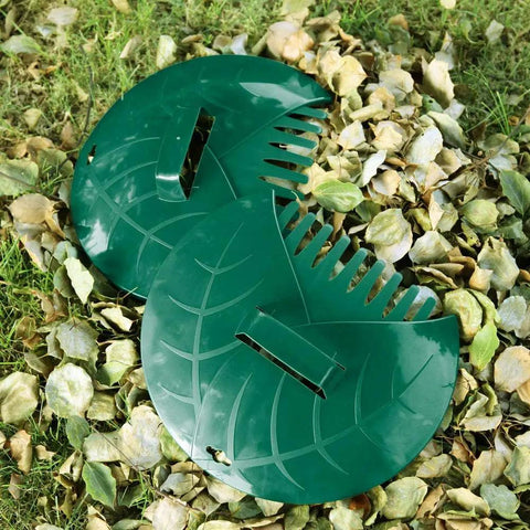 Green plastic leaf-shaped attachments on the ground with fallen leaves, part of Tough As Nails Adjustable 43 To 63 Inch Long Turf Rake.