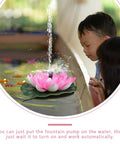 Children observing Solar Powered Floating Lotus Fountain For Fish Tanks And Gardens, Lily Pad Design in operation