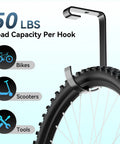 Close-up of rust-resistant black bike hook holding a bike wheel, 4 Pack Bike Hooks For Garage Ceiling Storage Rack Heavy Duty Steel Hangers Up To 50 Lbs Each Overhead Bike Hanger Add On For Wall Shelving And Garage Organization Rust Resistant Black.