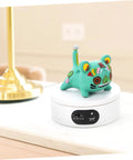 Rotatable Jewelry Display Stand With Electric Motorized Turntable Skid Base showcasing a colorful cat figurine on a white base.