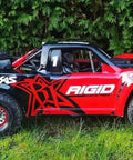 Side view of a Traxxas UDR Unlimited Desert Racer on grass, featuring Hardened Steel Ring Gear And Planetary Gear Set for 1:7 scale.