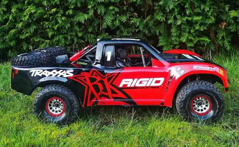 Side view of Traxxas UDR RC truck on grass, related to Planetary Gears Housing For UDR Traxxas Unlimited Desert Racer 1to7.