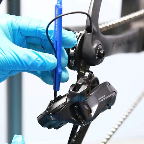 Hands using ETube Di2 Plug Cable Tool For Shimano Di2 12Speed SD300 Cables Lightweight Polymer on a Shimano Ultegra bike component