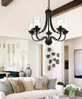 Affordable Luxury Five Light Farmhouse Chandelier In Classic Black Finish hanging in a modern living room with clear glass shades.