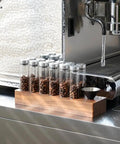 12 Piece Single Dose Coffee Bean Storage Tubes With One Way Exhaust Valve Glass Vials On Sturdy Walnut Wood Base and Easy Pouring Funnel for fresh beans.