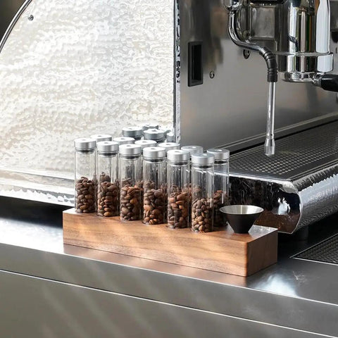 12 Piece Single Dose Coffee Bean Storage Tubes With One Way Exhaust Valve Glass Vials On Sturdy Walnut Wood Base and Easy Pouring Funnel for fresh beans.