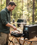 Man using Plug And Play 3KW V2L Power Adapter Gun For Tesla Model 3 Y S X With Clear Lcd Display while grilling outdoors.