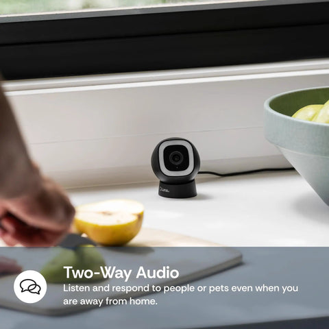 2K QHD Security Camera for Indoor and Outdoor Use For Home Security With 2.4GHz Wired or WiFi, shown on a table near a window.