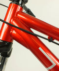 Close-up of Salire SJ-50 Dirt Jumper Bike With Disc Brakes And 26 Inch Wheels, red steel frame detail and suspension fork.