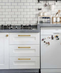 Champagne Bronze Single Hole Cabinet Knobs Two Pack With Tough As Nails Zinc Alloy Build showcased on modern kitchen drawers.
