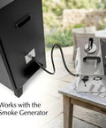 Smooth Operator Vertical Electric Smoker 1600W with smoke generator connection on a patio table.