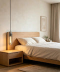 PRTSER 11.8" Modern Pendant Light Fixture with Smoke Gray Crystal Lampshade, hanging above a cozy bedroom beside a nightstand.