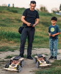 Child and adult playing with RC Robot Car Kit For Kids Aged 8 To 16 Kid Friendly With Mecanum Wheels in park setting