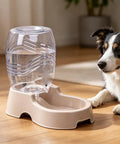 Set It And Forget It Gravity Pet Waterer Keeps Your Pooch Fully Hydrated With Large Capacity Plastic Bowl Featuring Non Slip Base And Whisper Quiet Auto Refill For Dogs And Cats In Beige next to a dog.