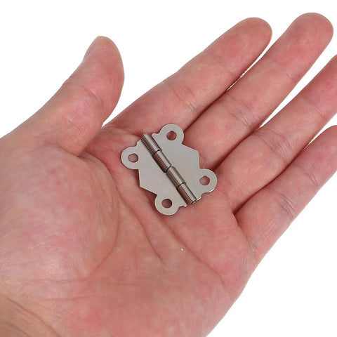 Hand holding a piece from 24 Piece Vintage Butterfly Hinges With Replacement Screws For DIY Furniture Projects Sturdy Iron Hardware