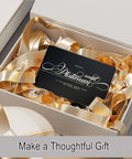 Gift box featuring Fifty Pcs Matte Black Metal Business Card Blanks For Laser Engraving, surrounded by gold ribbon.