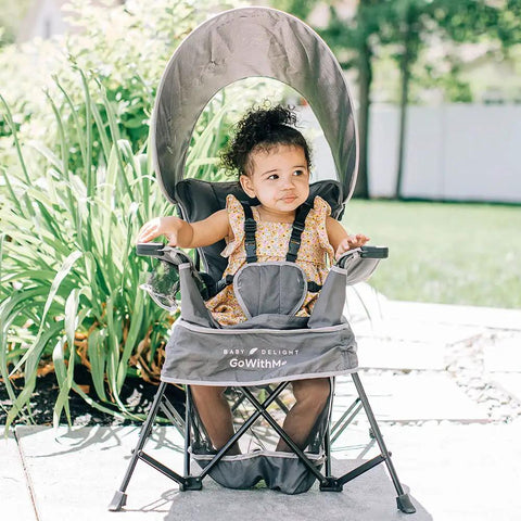 Child sitting in Go With Me Venture Portable Toddler Chair On The Go With Sun Canopy For Indoor And Outdoor Use, Grey, outdoors
