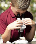 Boy using Battery Powered Binocular Stereo Dissecting Microscope With 20X Magnification, LED Illumination, And Interchangeable 5X And 10X Eyepieces on a shell